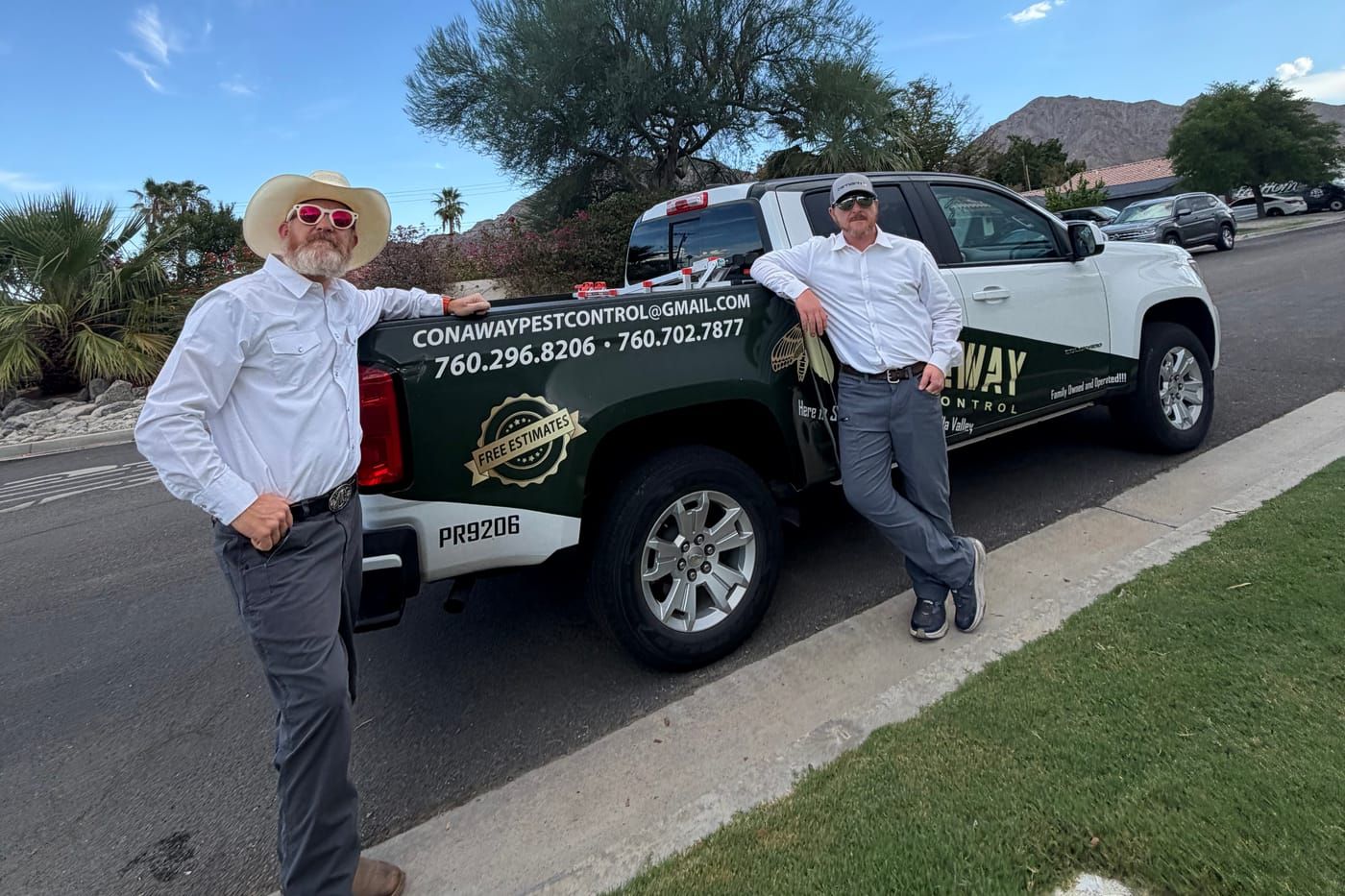 Curry and Kyle Conaway standing beside their Conaway Pest Control truck on a residential street in the Coachella Valley